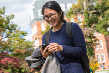 Smiling student walking across campus